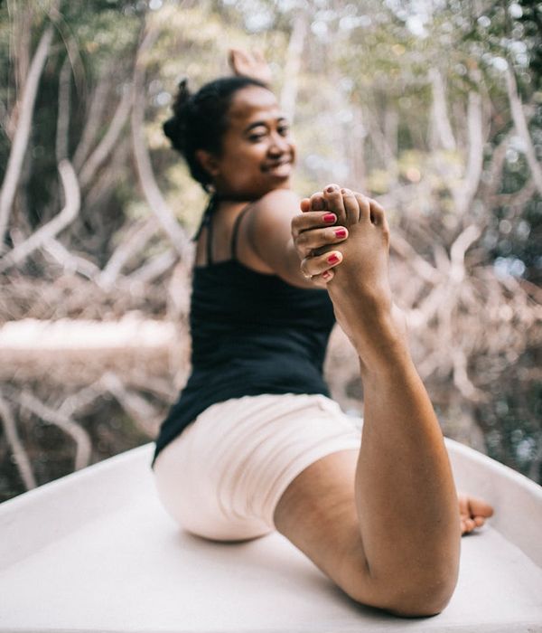 Woman in a peaceful yoga pose in a bright, serene environment.